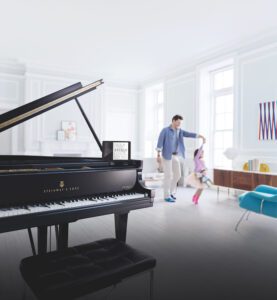 Steinway grand in foreground with father, daughter dancing