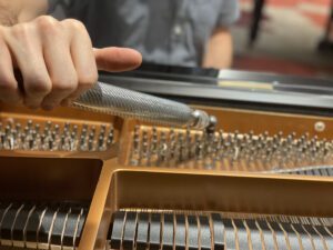 Piano tech tightening piano strings
