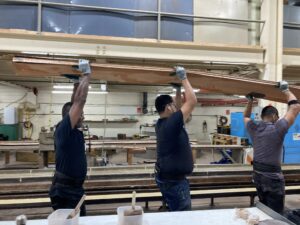 Steinway workers carrying the rim to bend into shape