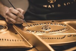 Photo of Steinway logo being painted in a piano interior