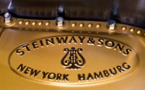 A Steinway piano plate with New York and Hamburg listed.
