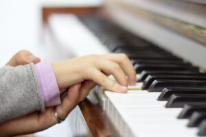 Piano teacher helping young student