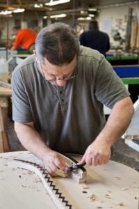 Photo of Steinway craftsman working on a soundboard